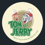 Pegatina Redonda Tom and Jerry Holiday Logo<br><div class="desc">Check out this cute Tom and Jerry logo featuring their smiling faces with festive Santa hats on.</div>