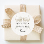 Pegatina Redonda Tying the knot ivory bow pearls Bridal Shower<br><div class="desc">Elevate your celebration with these chic bridal shower stickers. The design showcases a high-fidelity ivory,  cream colored bow intertwined with delicate pearl strands for a luxury finish. These labels are perfect for sealing bachelorette party invitation envelopes or adding to guest favor bags.</div>