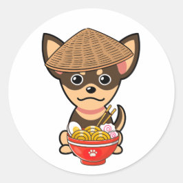 Pegatina Redonda Un perro pequeño y gracioso es comer fideos