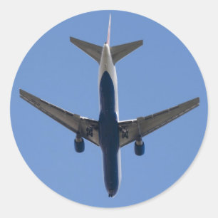 Pegatina Redonda Un solo avión en el fondo azul del cielo