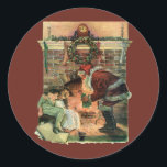 Pegatina Redonda Vintage Christmas, victoriano Santa Claus Children<br><div class="desc">Ilustracion de época Victorian Festividad navideña Feliz Navidad con un alegre Papá Noel entregando juguetes a dos niños durmiendo cerca de la chimenea en la Noche Navidad. La niña está recibiendo una muñeca de juguete. Una corona de hojas huecas está colgada en el manto sobre el fuego.</div>