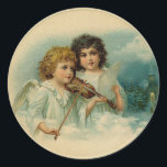 Pegatina Vintage Christmas Angels<br><div class="desc">Difundan algunos Navidades animando y celebran la temporada festiva con este adorable pegatina redondo clásico de los ángeles de Navidad de época, que presenta un ilustracion de ángeles encantadores: un ángel está tocando violín y el otro canta, escena de la iglesia de invierno al fondo. Es una forma fácil de...</div>
