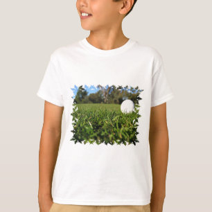 Pelota de golf en camiseta juvenil del campo de go