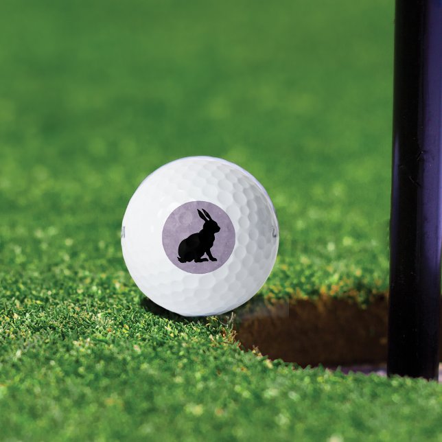 Pelotas De Golf Conejo de Semana Santa de Conejo Negro (Black sitting rabbit in silhouette form on marbled light purple background on golf balls.)