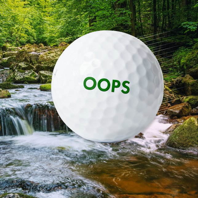 Pelotas De Golf Gracioso Chiste de humor "Oops" Novedad extravagan (A funny novelty golf ball with 'Oops' caption in green on a classic white background)