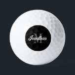 Pelotas De Golf Guión de pincel retro Monograma blanco gris negro<br><div class="desc">Esta pelota de golf personalizada presenta su nombre en un guión de broche retro blanco inspirado en vintage sobre su monograma inicial en serif gris sobre fondo negro. Un diseño sencillo pero distintivo que hace un gran regalo para un hombre o una mujer.</div>