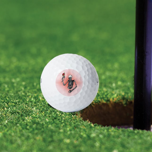 Pelotas De Golf Skeleton gótico Una Rosa Roja (Skeleton holding single red rose on stem on pink background on golf balls.)