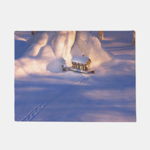 Pequeña casa en el felpudo de nieve