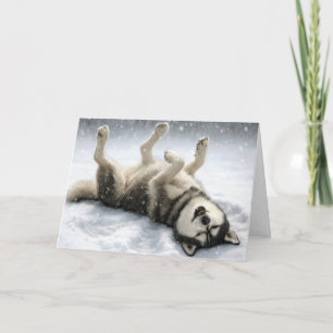 Perro Husky Siberiano de Navidad haciendo un ángel