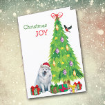 Perro samoyado, pájaro y árbol de Navidad<br><div class="desc">En la parte delantera de esta tarjeta de Navidades, un hermoso perro Samoyed lleva un gorra de Santa Claus rojo y blanco mientras se sienta junto a un árbol de vacaciones. Los paquetes de regalo envueltos de forma brillante están dispersos por todo el mundo, y un bullfinch está aterrizando en...</div>