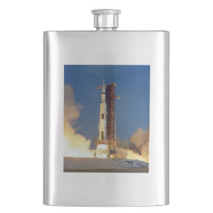 Petaca La Tierra tiembla mientras el Saturn V ilumina el