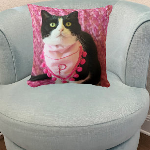 Pica la almohada rosa del gato de Tuxedo