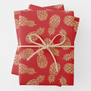 Piñas de oro en hojas de papel de envolver rojas
