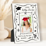 Placa Expositora Doodle de Foto Personalizada Felicidades Graduado<br><div class="desc">Una encantadora placa de graduación que presenta una foto de último año rodeada de un caprichoso borde de doodle dibujado a mano con un gorro de graduación, estrellas y confeti sobre un fondo blanco limpio. El titular de Felicidades da paso al nombre del graduado en letra cursiva con el nombre...</div>