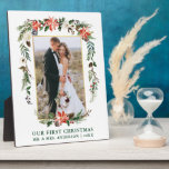Placa Expositora Nuestra primera acuarela de Navidad Poinsettia Pho<br><div class="desc">Elegante acuarela Poinsettias Nuestra primera placa de fotografía Boda de Navidad recién casada incluye hermosas poinsettias de color rojo acuático,  vegetación botánica,  follaje de invierno,  bayas huecas,  rosas blancas,  algodón,  conos de pino y bayas azules.  Marco dorado. Texto verde.</div>