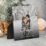 Placa Expositora Primer guión blanco de foto de Personalizado invol<br><div class="desc">Conmemorar su compromiso con esta hermosa placa moderna de keepsake. El texto blanco dice "Nuestra primera Navidad comprometida", con la palabra "comprometida" en un elegante guión de escritura a mano con flores antes y después. Reemplace la imagen de ejemplo con su foto favorita y agregue sus nombres y el año....</div>