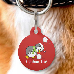 Placa Para Mascotas pingüino de Navidad recogiendo una bola de nieve
