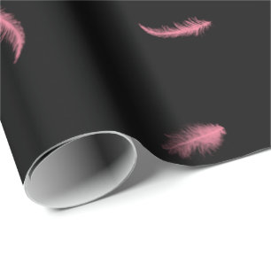 Plumas rosadas sobre papel de envolvimiento negro