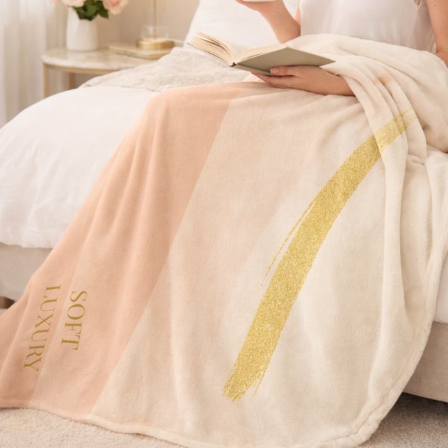 Polar Manta de felpa dorada con rubor de marfil (A soft ivory base with blush fade and gold contrast for refined bedroom layering.)