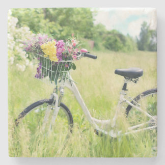 Posavasos De Piedra Bicicleta con cesta de flores en la pradera