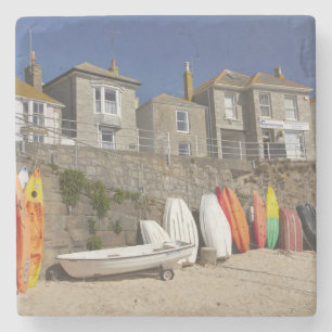 Posavasos De Piedra Kayaks y botes amontonados contra el malecón