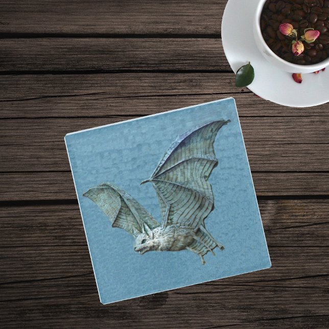 Posavasos De Vidrio Espeluznante volando Blue Bat White Face mostrando (Spooky flying blue bat with white face on blue glass drink coaster.)