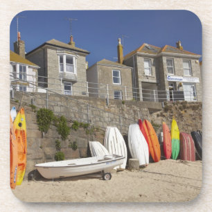 Posavasos Kayaks y dinghies apilados contra el muro del mar 