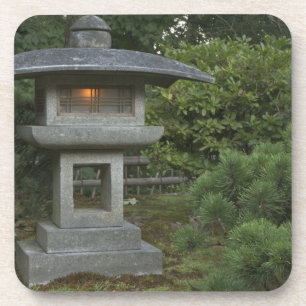 Posavasos Linterna de piedra iluminada en un jardín japonés
