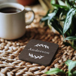 Posavasos Monograma del nombre del laurel de la madera oscur<br><div class="desc">Este sencillo y elegante personalizado monogramado estuche de galletas con ramas de laurel que enmarcan un apellido familiar. Un hermoso regalo de mantenimiento para recién casados o nuevos propietarios. Un fondo de madera oscura marrón marrón oscuro aporta un toque rústico de textura al diseño. El texto clásico del serif blanco...</div>