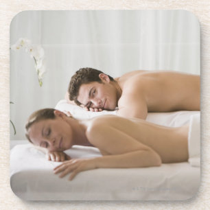 Posavasos mujer y hombre que mienten en bancos del masaje