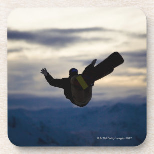 Posavasos Un snowboarder de sexo masculino hace un salto