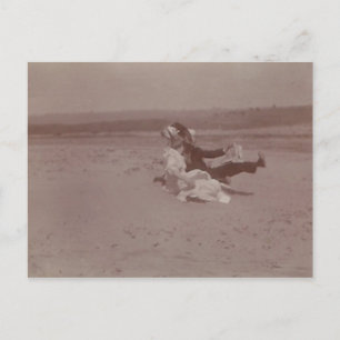 Postal 2 personas en la playa perdiendo gorras