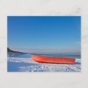 Postal Barco rojo a orillas del mar Báltico en invierno