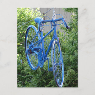 Postal Bicicleta colgando sobre la calle