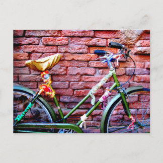 Postal Bicicleta verde inclinada contra una pared de ladr