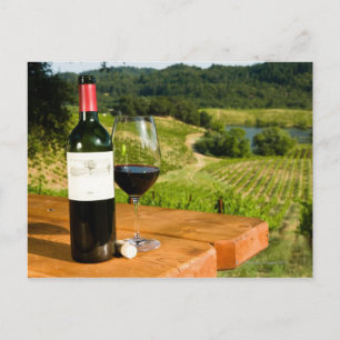 Postal Botella de vino tinto y de vidrio en la mesa