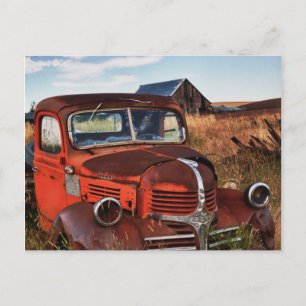 Postal Camión Dodge naranja oxidado con granja abandonada