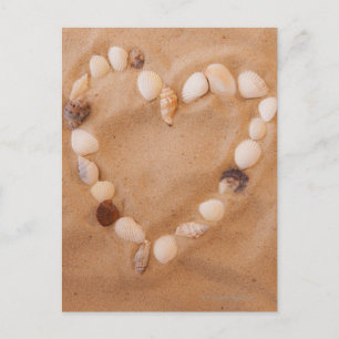 Postal Cercano a la forma del corazón de conchas en la ar