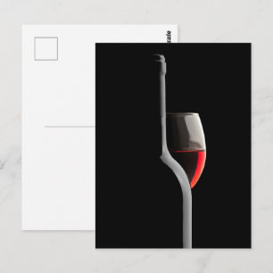 Postal Copa de vino rojo elegante y botella. Fondo negro