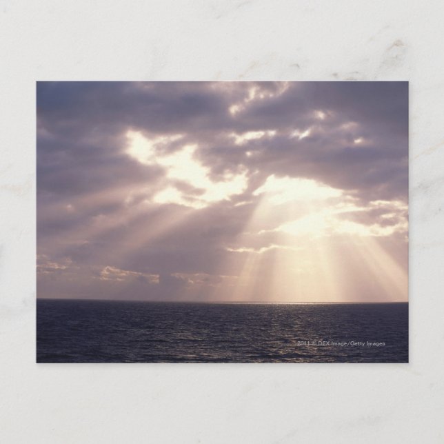 Postal El sol brilla a través de las nubes sobre el océan (Anverso)