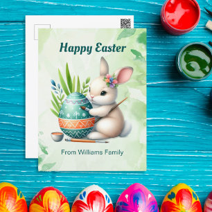 Postal Festiva Feliz Pascua, dulce conejita pintando un huevo de