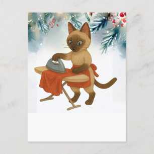 Postal Festiva Un gato siamés plancha un vestido para Navidades