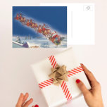 Postal Festiva Vintage Christmas, Santa Flying Sleigh w Reindeer<br><div class="desc">Ilustracion de la Vintage. Imagen de feriado navideño con un alegre Santa Claus con su reno. Están volando su trineo lleno de juguetes a través del cielo azul y sobre un pueblo dormido cubierto de nieve en invierno en la víspera de los Navidades. Ho, ho, ho Happy Holidays and Season's...</div>