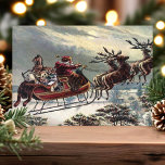 Postal Festiva Vintage Flying Santa Sleigh Reindes Navidades<br><div class="desc">Vintage Flying Santa Sleigh Reindeer Navidades de vacaciones. Este diseño presenta un santa claus vintage que vuela en trineo con su reno. Qué hermosa escena de vacaciones retro.</div>
