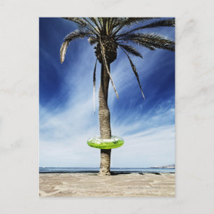 Postal Gran palmera en una playa de arena hinchable