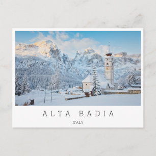 Postal Iglesia cubierta de nieve con fondo de montaña