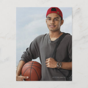 Postal joven con gorro rojo sosteniendo una bola de cesta