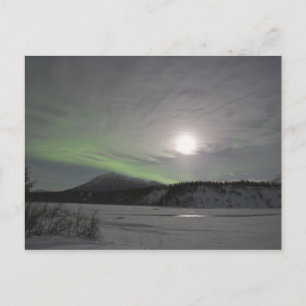 Postal La luna se eleva sobre una cortina de aurora borea