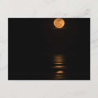 Postal luna llena dorada sobre el océano