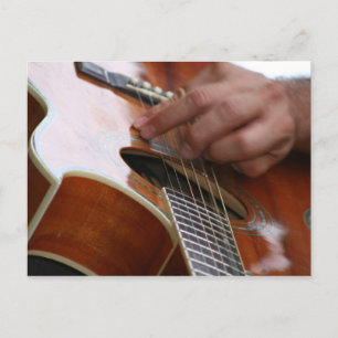 Postal mano masculina sujetando la guitarra acústica